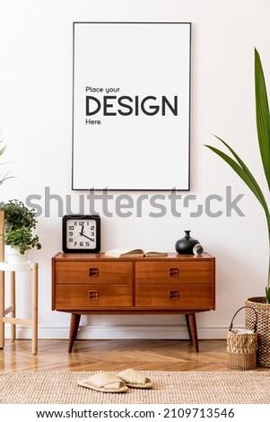 Stylish and retro composition of living room with design wooden retro commode, clock, a lot of plants and elegant accessories. Modern home decor. Template. Mock up poster frame on the wall. 