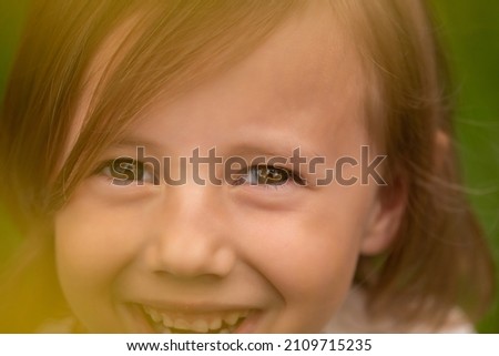 Portrait of cute little caucasian girl in casual closing in the forest against the background of grass summertime
