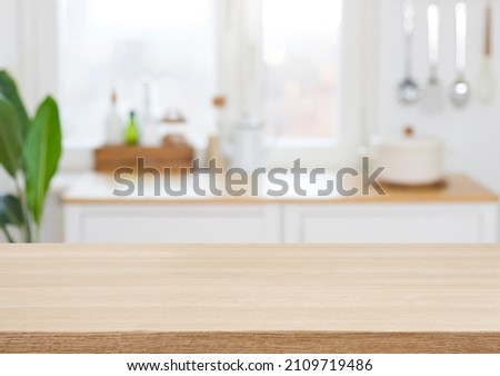 Empty wooden desk on blurred kitchen window for product presentation