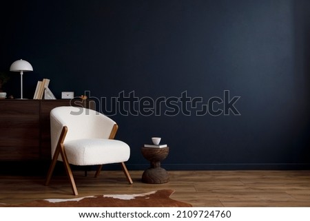 Modern living room interior composition with fluffy armchair, wooden commode and modern home accessories. Blue wall. Template. Copy space. Home staging. Royalty-Free Stock Photo #2109724760