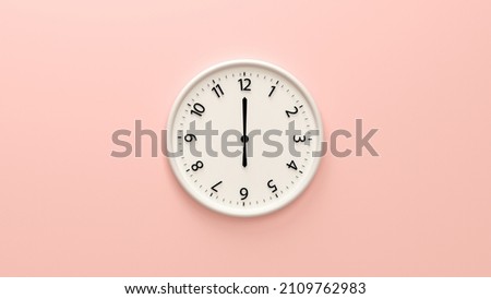 Closeup white wall clock set on light pink background.  White wall clock hanging on the wall. Minimalist flat lay image of plastic wall clock over pink background. Copy space and central composition. Royalty-Free Stock Photo #2109762983