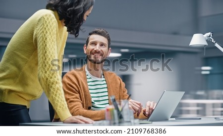 Modern Office: Business Meeting of Two Businesspeople Talking at the Desk. Businessman and Businesswoman Work on Strategy, Brainstorm for e-Commerce Software Design. Shot with Motion Blur Background Royalty-Free Stock Photo #2109768386