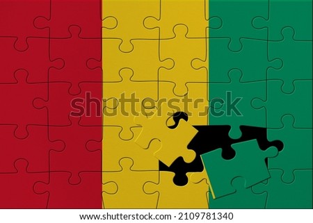 World countries. Broken puzzle- background in colors of national flag. Guinea