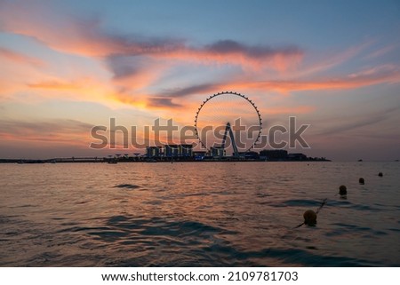 Amazing sunset colors over the sea view to the Ain Dubai, giant Ferris at Bluewaters Island  close to JBR beach. Dubai Eye fits perfect to modern UAE skyline Royalty-Free Stock Photo #2109781703