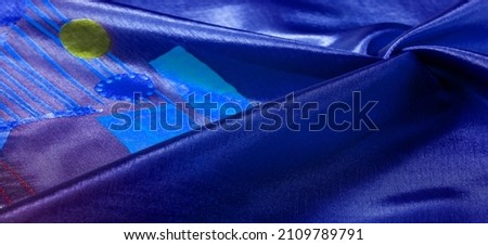 Background texture, silk fabric, shiny blue burgundy, with a small abstract print of rock paintings