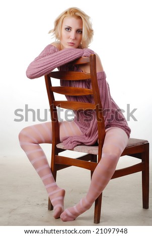 portrait of a blond woman in a wool sweater on a chair