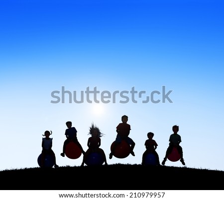 Silhouettes of Children Playing on Balls and Copy Space Above