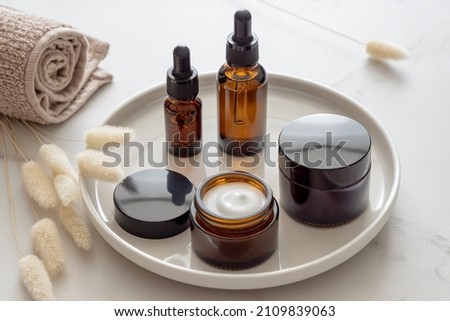 Cosmetics packaging. Set of different cosmetic bottles of cream or serum on a ceramic tray. Blank packaging. Natural beauty spa product concept. Beauty.Mock-up Royalty-Free Stock Photo #2109839063