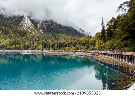 Horizontal view at the plank road along the Long Lake with the people on it, Jiuzhaigou Valley Scenic Area, Sichuan, China  Royalty-Free Stock Photo #2109853325