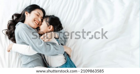 Asian mother and daughter image in bed