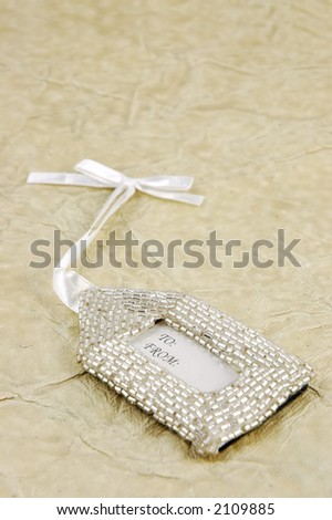Elegant beaded gift tag on a textured background