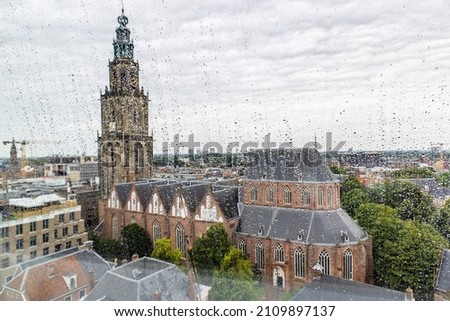 Scenic view of Martini church from through windows with raindrops of Forum building in the center of city of Groningen in The Netherlands