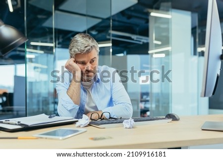 sad gray-haired architect man working in modern office at computer, businessman thinking about failures Royalty-Free Stock Photo #2109916181