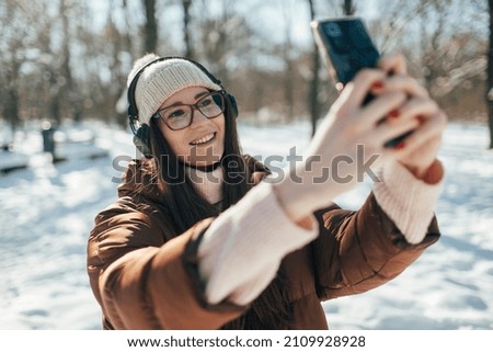Millennial girl making selfie photo with mobile phone on mobile phone