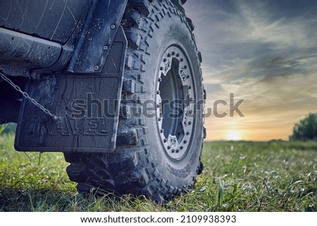 An off-road car splattered with mud against a beautiful sky. Car tire and mudguard 4x4. Off-road tire Royalty-Free Stock Photo #2109938393