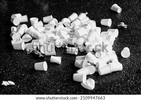 Pile of used disposable white cardboard cups for water on asphalt, concept of ecologic garbage and recycling Royalty-Free Stock Photo #2109947663