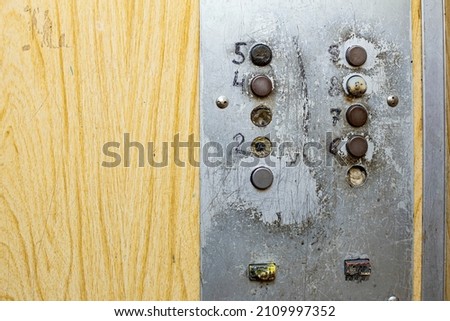 old elevator buttons with closed elevator shaft doors, front and back background blurred with bokeh effect
