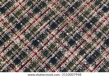 Green checkered fabric with colored threads. Scottish wool. Fabric for a plaid coat and suit. Close-up. Background