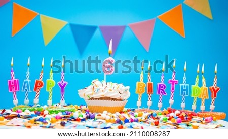 A word made from candle letters happy birthday to a child with the number six on a beautiful blue background. Copy space Happy birthday greetings for 6 years old, lit candles with holiday decorations.