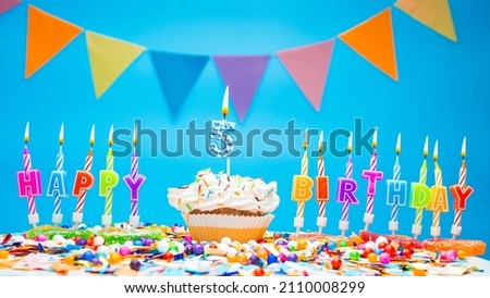 A word made from candle letters happy birthday to a child with the number five on a beautiful blue background. Copy space Happy birthday greetings for 5 years, lit candles with holiday decorations. Be