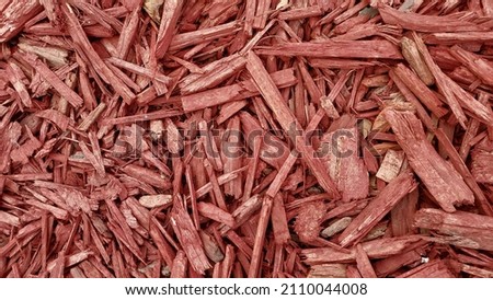 Red wood chips covering the background. 