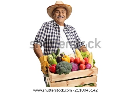 Mature farmer carrying a crate full of fresh vegetabales isolated on white background Royalty-Free Stock Photo #2110045142