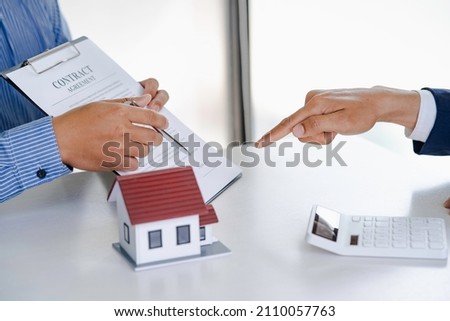 The real estate agent explains the information in the contract and the client is discussing a home purchase contract, insurance, or real estate loan.