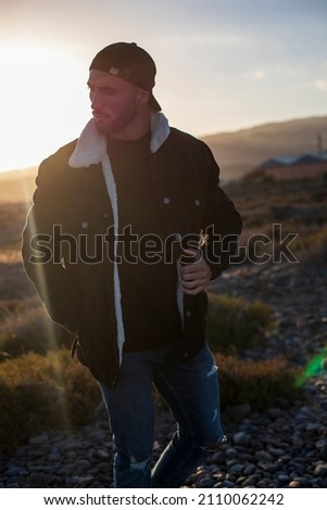 muscular caucasian man posing with sunset. street style photography. SPACE FOR TEXT
