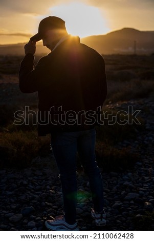 muscular caucasian man in cap posing with sunset. Street style photography. space for text