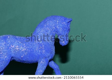 head and body part of a blue horse on a green background