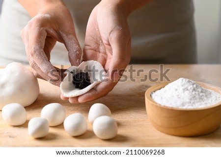 Hand making Tangyuan, Chinese dessert made of ball glutinous rice flour and filled with black sesame, Sweet rice ball Royalty-Free Stock Photo #2110069268