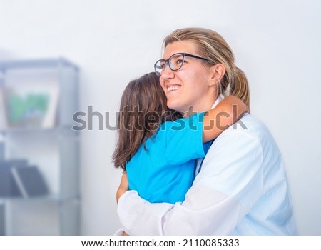 Child patient hugging doctor with confidence in office