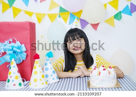 Happy young girl with cake on birthday party on white background.