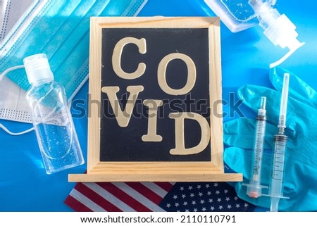 Antivirus protection kit on blue background, mask, rubber gloves, hand sanitizer bottles, antiseptic gel and Cavid19 vaccine syringes.