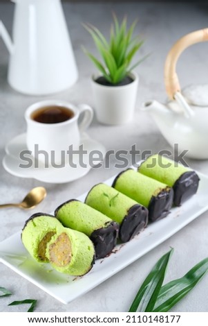 Banana roll cake with chocolate dessert served in white plate on white table. Selective focus.