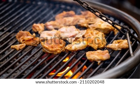 Grilled chicken breast on the flaming grill, real picture, dark background