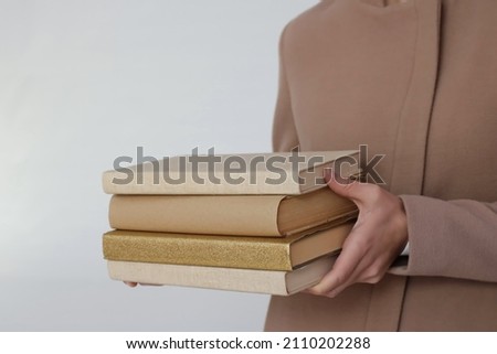 A young beautiful girl holding books in her hands