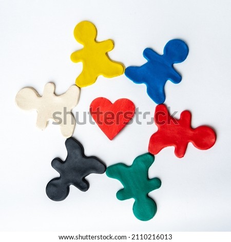 Red heart shape in the center and multicolored bright plasticine people in a circle isolated on white background Royalty-Free Stock Photo #2110216013