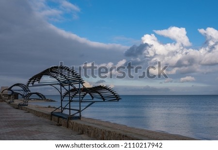 Canopies from the sun on the deserted beach of the Sea of Azov on a winter day against the backdrop of beautiful clouds.