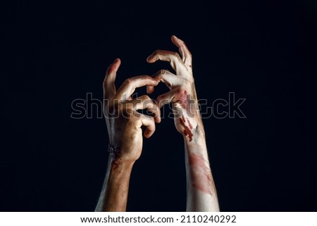 Hands of zombie on dark background