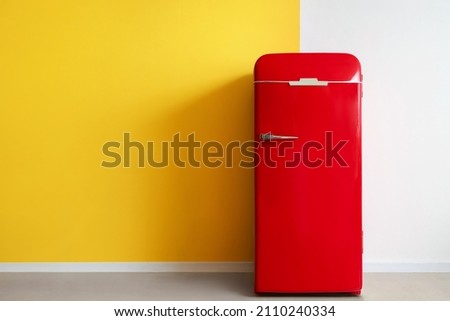 Red fridge near yellow and white wall