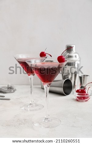 Glasses of delicious Manhattan cocktail on light background