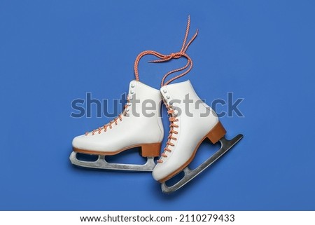 Ice skates on blue background Royalty-Free Stock Photo #2110279433