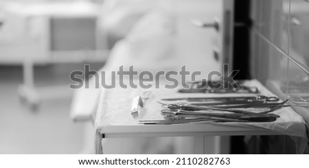 Sterile surgical instruments on the table in the hospital. Selective focus. Black and white photo. Copy space.