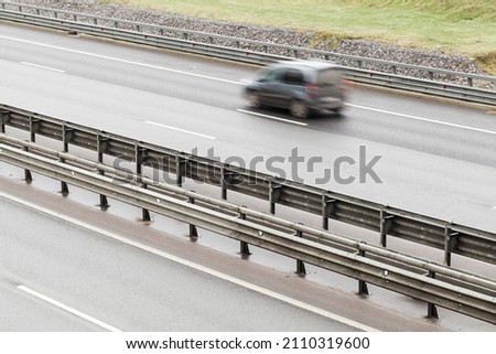 Fast blurred car is on a highway with dividing structure, abstract transportation background photo