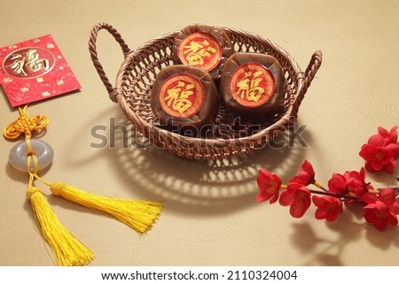 Chinese New Year Cake or Nian Gao (with Chinese character "Fu" means Fortune). Popular as Kue Keranjang or Dodol China in Indonesia. Served on Rattan tray, Imlek Red Decoration