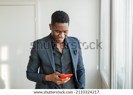portrait of a handsome man in a suit with a mobile phone in the office	
