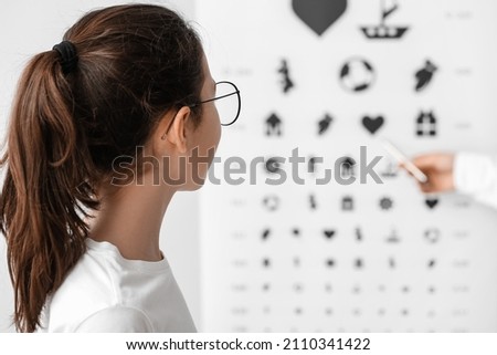 Little girl undergoing eye test in clinic Royalty-Free Stock Photo #2110341422