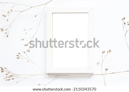 empty white wooden frame and dry autumn flowers
