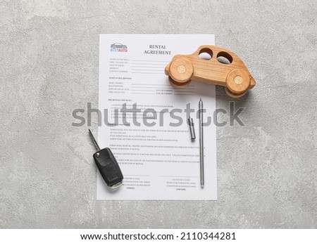 Rental agreement, car key, pen and wooden car on grey background